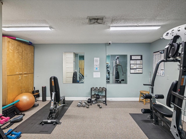 workout area with a textured ceiling, baseboards, and visible vents
