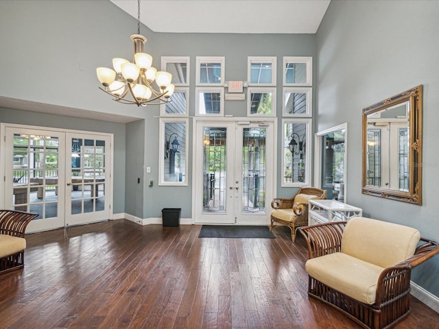 interior space featuring a notable chandelier, french doors, and a towering ceiling