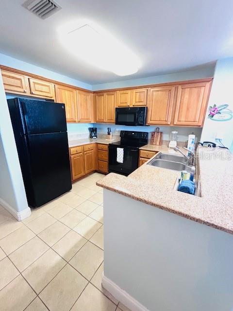 13415 Blue Heron Beach Dr Unit 1006, Orlando, FL 32821 - kitchen featuring a sink, light tile patterned floors, black appliances, and visible vents