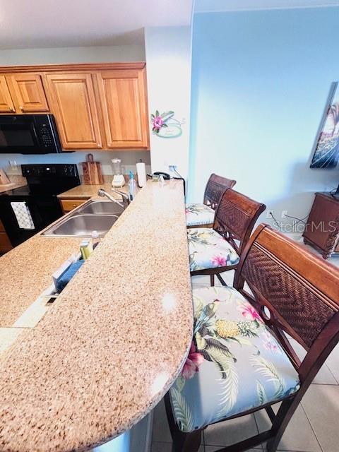 13415 Blue Heron Beach Dr Unit 1006, Orlando, FL 32821 - kitchen featuring light countertops, a sink, and black appliances