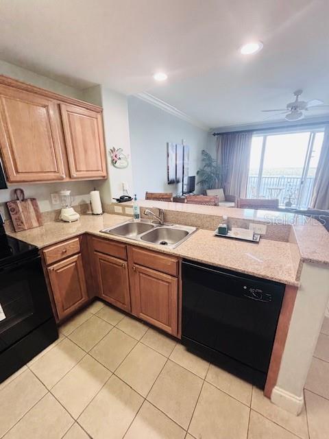 13415 Blue Heron Beach Dr Unit 1006, Orlando, FL 32821 - kitchen with a sink, a peninsula, light tile patterned flooring, a ceiling fan, and black appliances