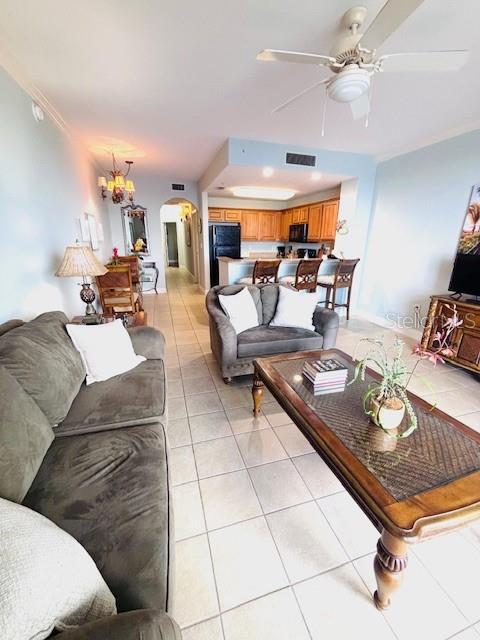 13415 Blue Heron Beach Dr Unit 1006, Orlando, FL 32821 - living room with visible vents, arched walkways, ceiling fan with notable chandelier, and light tile patterned flooring