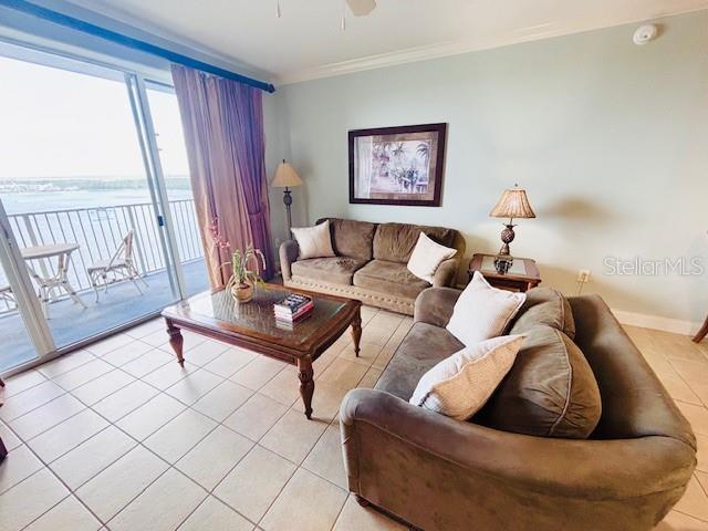 13415 Blue Heron Beach Dr Unit 1006, Orlando, FL 32821 - living area with light tile patterned flooring, a ceiling fan, ornamental molding, and baseboards