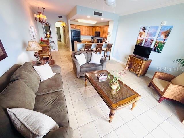 13415 Blue Heron Beach Dr Unit 1006, Orlando, FL 32821 - living area featuring arched walkways, ceiling fan, visible vents, and light tile patterned flooring