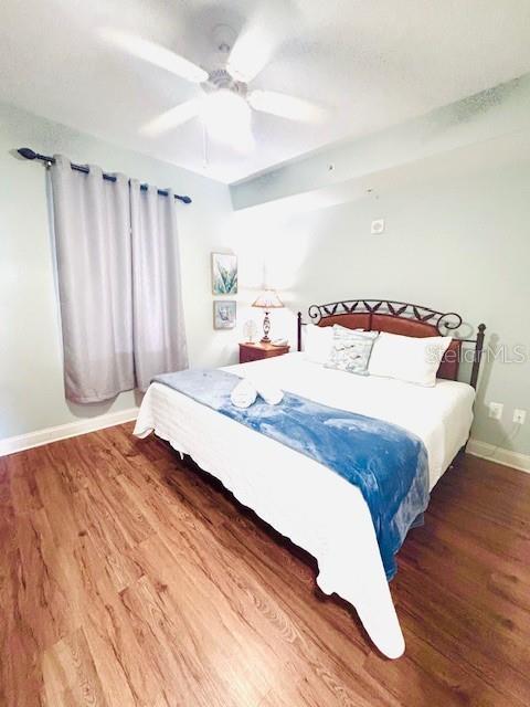 13415 Blue Heron Beach Dr Unit 1006, Orlando, FL 32821 - bedroom featuring baseboards, a ceiling fan, and wood finished floors