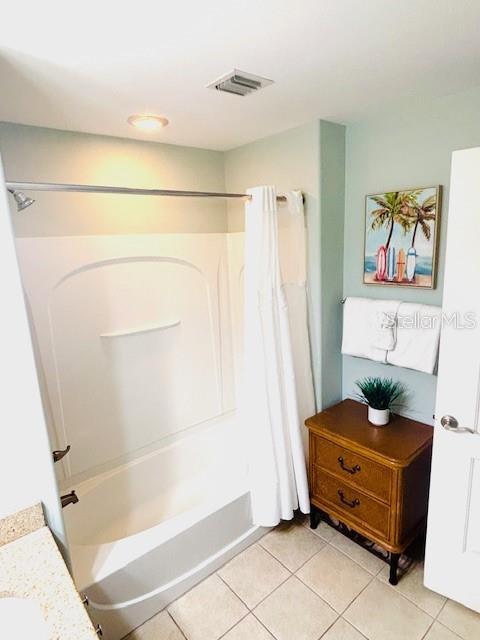 13415 Blue Heron Beach Dr Unit 1006, Orlando, FL 32821 - bathroom featuring tile patterned floors, shower / bathtub combination with curtain, and visible vents