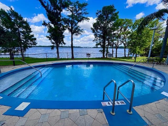 13415 Blue Heron Beach Dr Unit 1006, Orlando, FL 32821 - outdoor pool featuring a water view and fence
