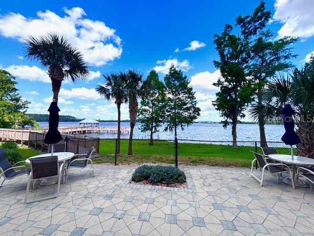 13415 Blue Heron Beach Dr Unit 1006, Orlando, FL 32821 - view of patio with a water view, fence, and outdoor dining area