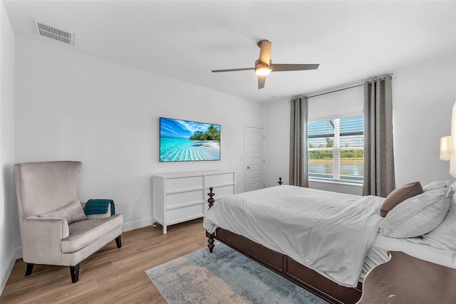 bedroom featuring visible vents, a ceiling fan, light wood-style floors, and baseboards