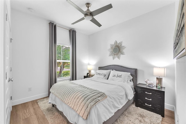 bedroom with a ceiling fan, baseboards, and wood finished floors