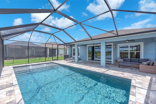 outdoor pool with a patio, a ceiling fan, glass enclosure, and outdoor lounge area