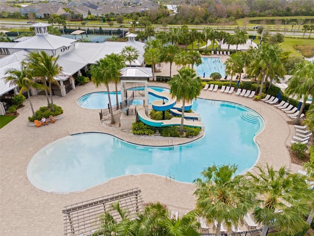 pool with a water slide and a patio area