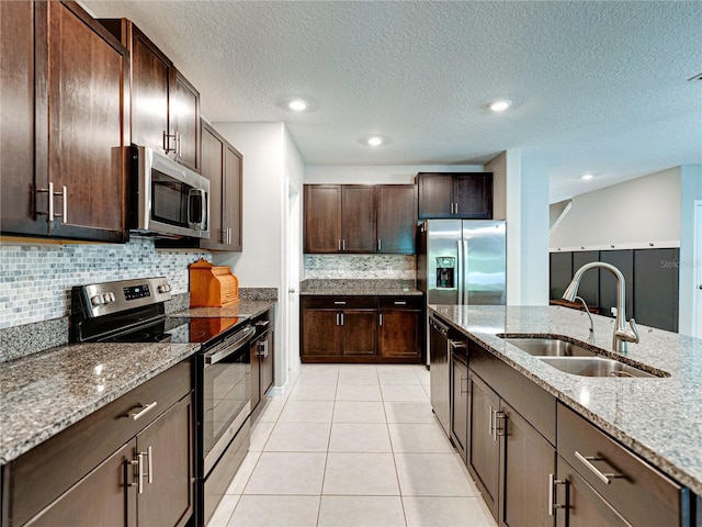 413 Royal Empress Dr, Ruskin, FL 33570 - kitchen featuring stainless steel appliances, a sink, dark brown cabinets, light tile patterned floors, and backsplash