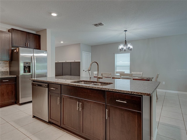 413 Royal Empress Dr, Ruskin, FL 33570 - kitchen with appliances with stainless steel finishes, a sink, light tile patterned flooring, light stone countertops, and dark brown cabinetry