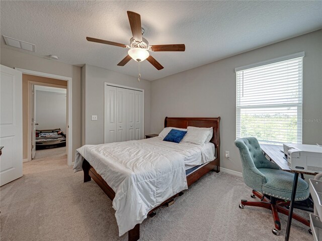 413 Royal Empress Dr, Ruskin, FL 33570 - bedroom with light colored carpet, a closet, a ceiling fan, a textured ceiling, and baseboards