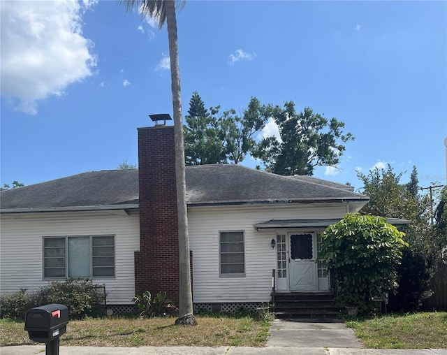 view of front of home with entry steps and a chimney