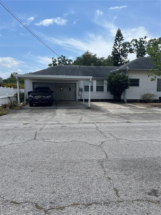 view of front facade with concrete driveway and fence