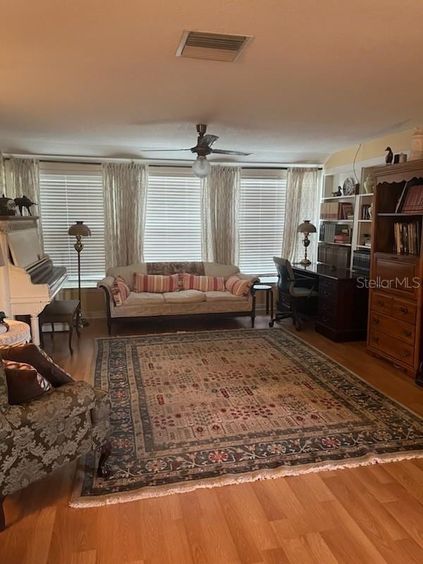 living area with visible vents and wood finished floors