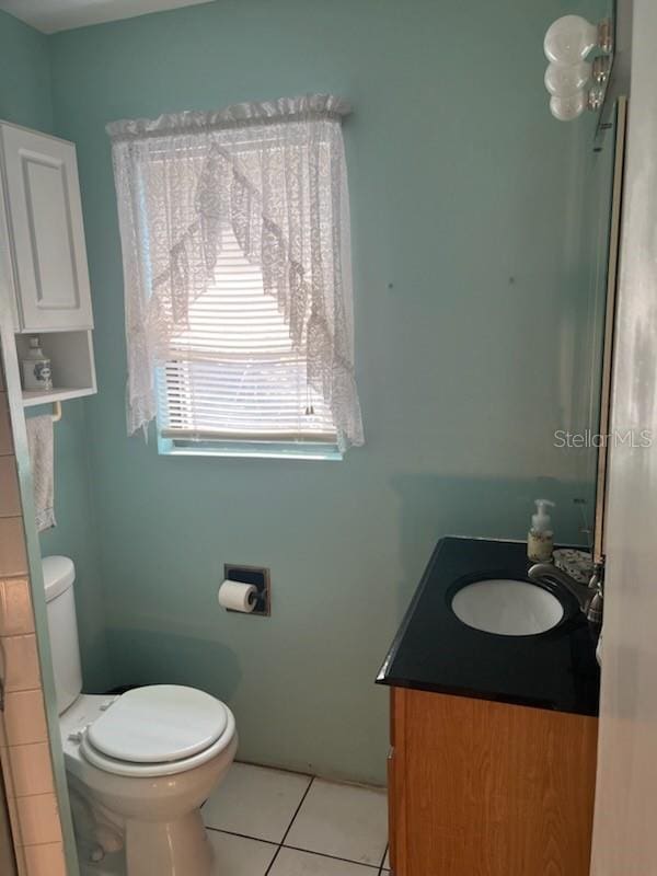 bathroom with toilet, tile patterned floors, and vanity