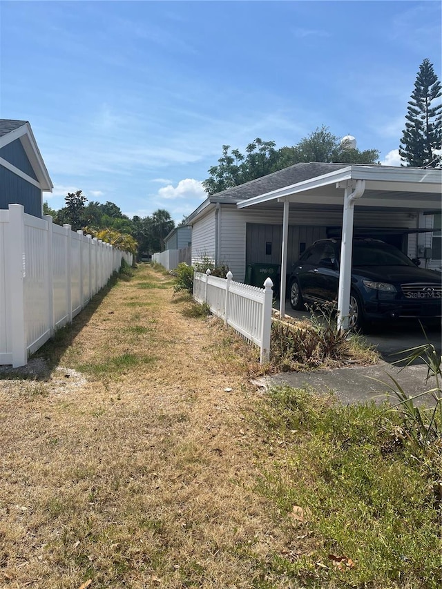 view of side of property featuring fence and a yard