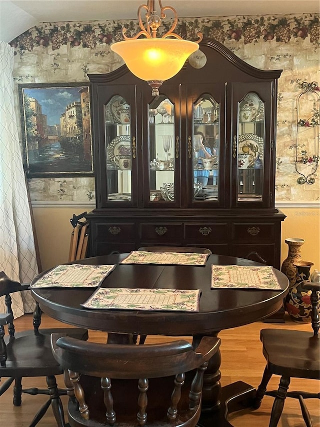dining area featuring wood finished floors and vaulted ceiling