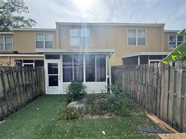 6405 Osprey Lake Cir, Riverview, FL 33578 - back of property with a lawn, stucco siding, and a sunroom