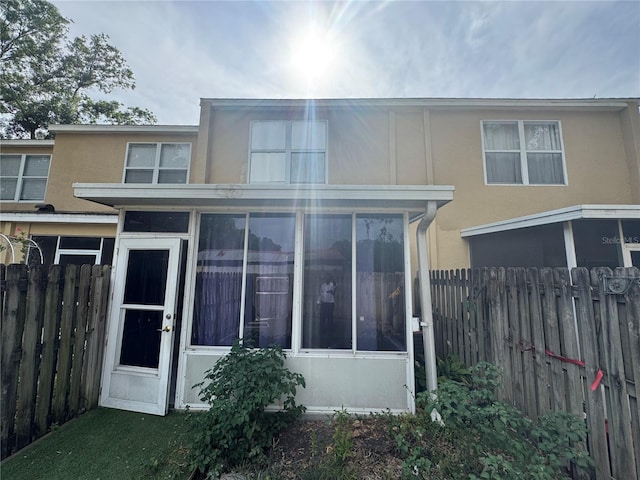 6405 Osprey Lake Cir, Riverview, FL 33578 - back of house featuring fence, stucco siding, and a sunroom