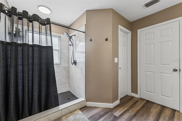 518 Royal Ridge St, Valrico, FL 33594 - full bathroom with baseboards, wood finished floors, tiled shower, and visible vents