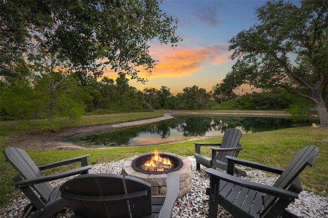 view of home's community featuring a water view, a fire pit, and a yard