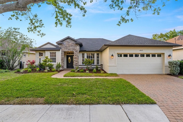 ranch-style house featuring a front yard, decorative driveway, an attached garage, stone siding, and stucco siding