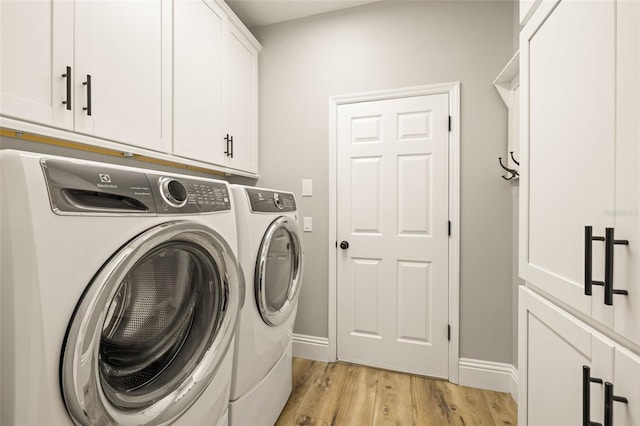 clothes washing area with baseboards, cabinet space, light wood finished floors, and independent washer and dryer