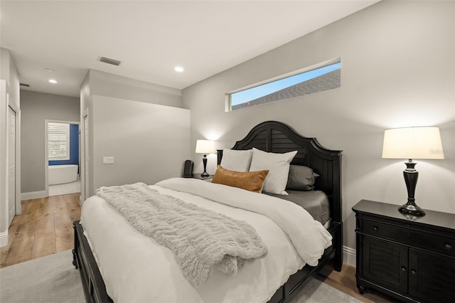 bedroom featuring a skylight, visible vents, baseboards, and light wood finished floors