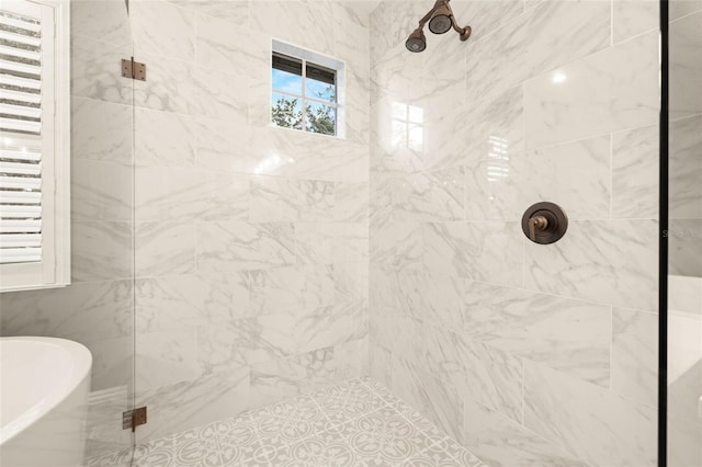 full bathroom featuring a soaking tub and a tile shower