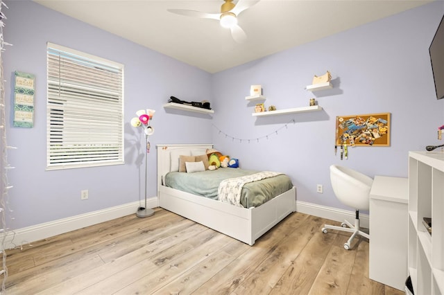 bedroom featuring baseboards, a ceiling fan, and light wood finished floors