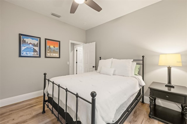 bedroom featuring baseboards, ceiling fan, light wood-style flooring, and visible vents