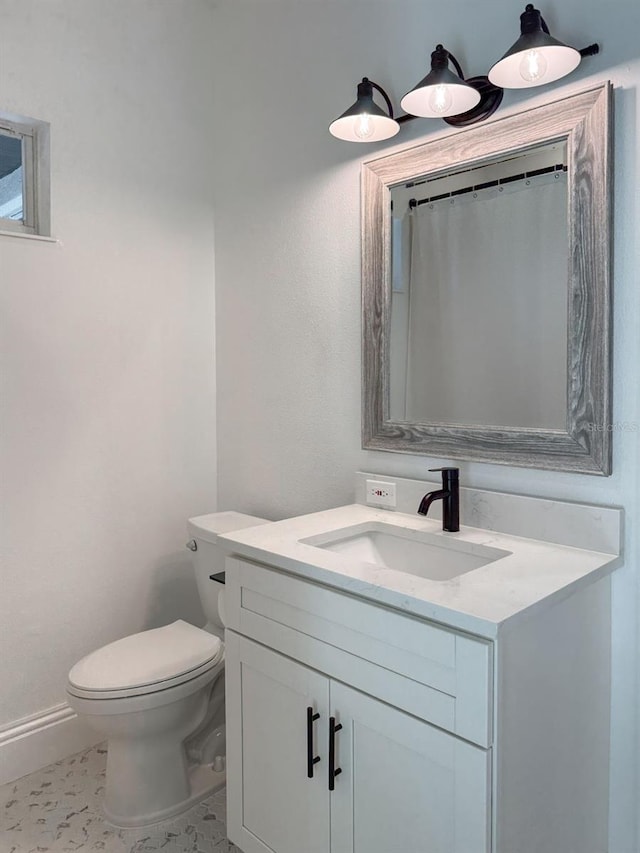 bathroom featuring vanity, baseboards, toilet, and tile patterned flooring
