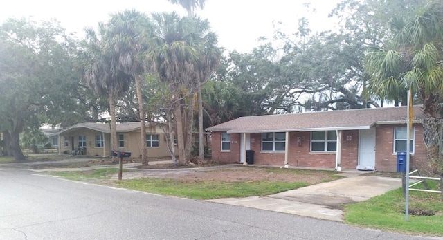 single story home featuring brick siding and driveway