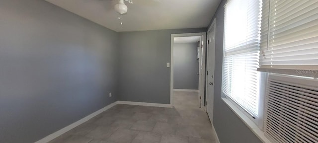 interior space featuring baseboards and ceiling fan