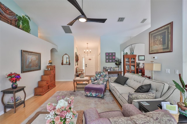 living area with ceiling fan with notable chandelier, light wood-type flooring, and visible vents