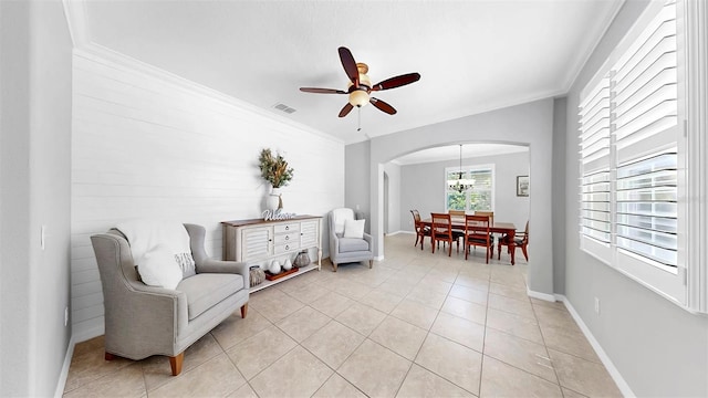 sitting room featuring visible vents, crown molding, light tile patterned flooring, arched walkways, and ceiling fan with notable chandelier