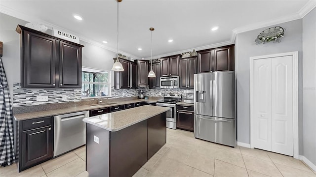 kitchen with a kitchen island, tasteful backsplash, a sink, ornamental molding, and stainless steel appliances