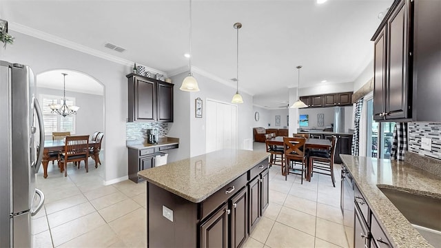 kitchen with stainless steel appliances, visible vents, decorative backsplash, and dark brown cabinets