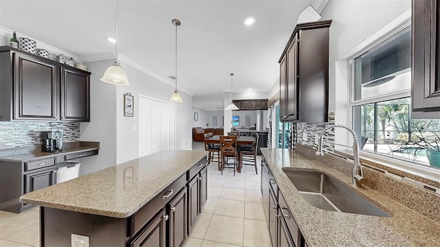 kitchen with crown molding, a sink, backsplash, and dark brown cabinets