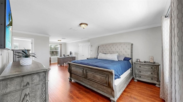 bedroom featuring ornamental molding and wood finished floors