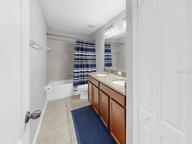 full bathroom with double vanity, toilet, a sink, and tile patterned flooring