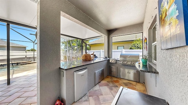 view of patio / terrace with fence, a grill, a fenced in pool, exterior kitchen, and glass enclosure