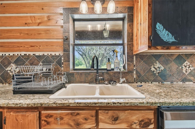 kitchen with a sink, light stone countertops, and tasteful backsplash