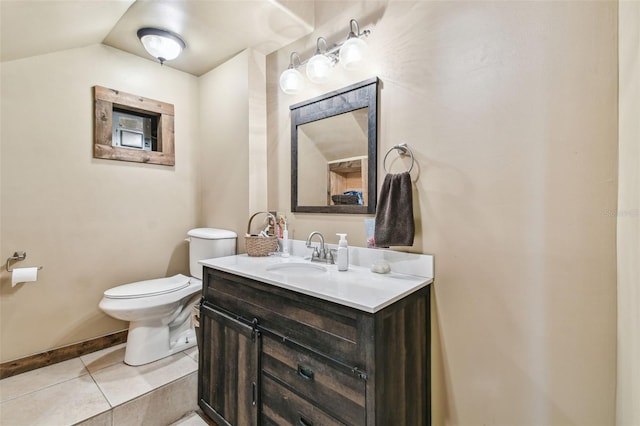 bathroom featuring vanity, toilet, baseboards, and tile patterned floors