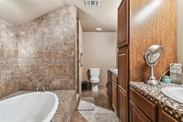 bathroom featuring toilet, visible vents, a bath, vanity, and vaulted ceiling