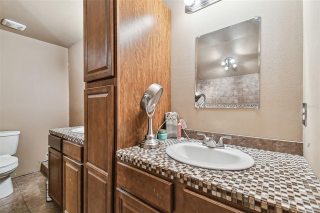 bathroom featuring toilet, tile patterned flooring, and vanity